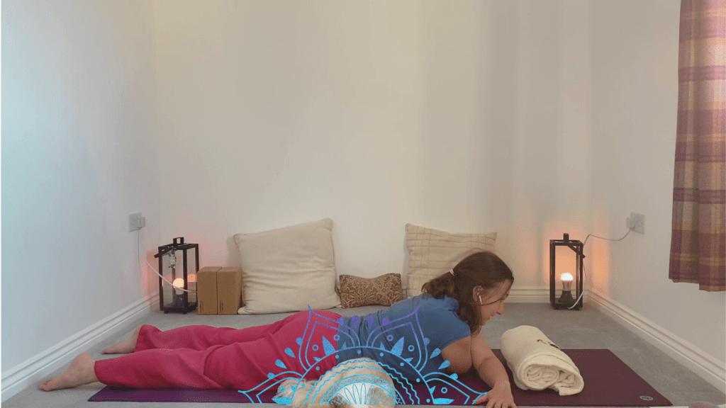 Yogi lying on stomach with arms crossed in front of chest - closed wing yin yoga pose